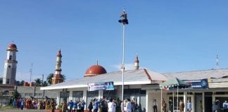 Personil Polres Aceh Selatan, Bripda Hubul Wahan memanjat tiang bendera untuk memasang tali yang putus saat berlangsungnya upacara memperingati Hari Sumpah Pemuda ke-90 Tahun 2018 di Kabupaten Aceh Selatan, Senin (29/10/2018)