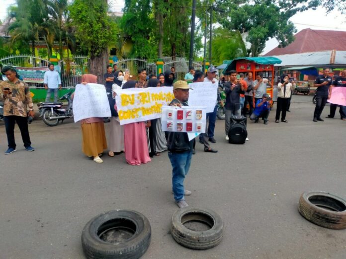 Sejumlah massa yang tergabung dari beberapa elemen masyarakat melakukan unjuk rasa di depan kantor Bea Cukai Langsa terkait dugaan sindikat rokok ilegal, Selasa (11/7/2023) siang. Foto: Analisaaceh.com/Chairul.
