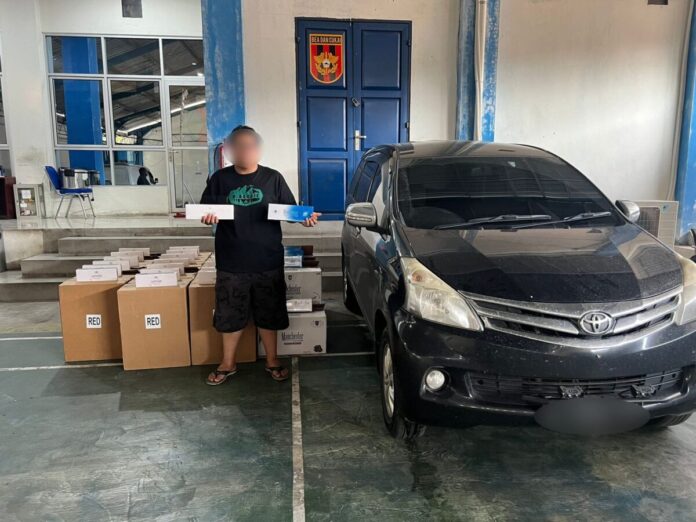 aa0922d6652da267559b9af84d4179a7 Seorang pelaku pengedar rokok ilegal bersama barang bukti yang diamankan Bea Cukai Langsa. Foto (ist).