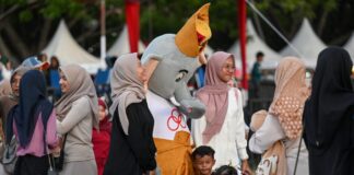 Pengunjung berfoto dengan maskot PON saat mengunjungi PON Expo di Lapangan Blang Padang, Banda Aceh, Aceh, Minggu (15/9/2024). ANTARA FOTO/Wahyu Putro A/pras.
